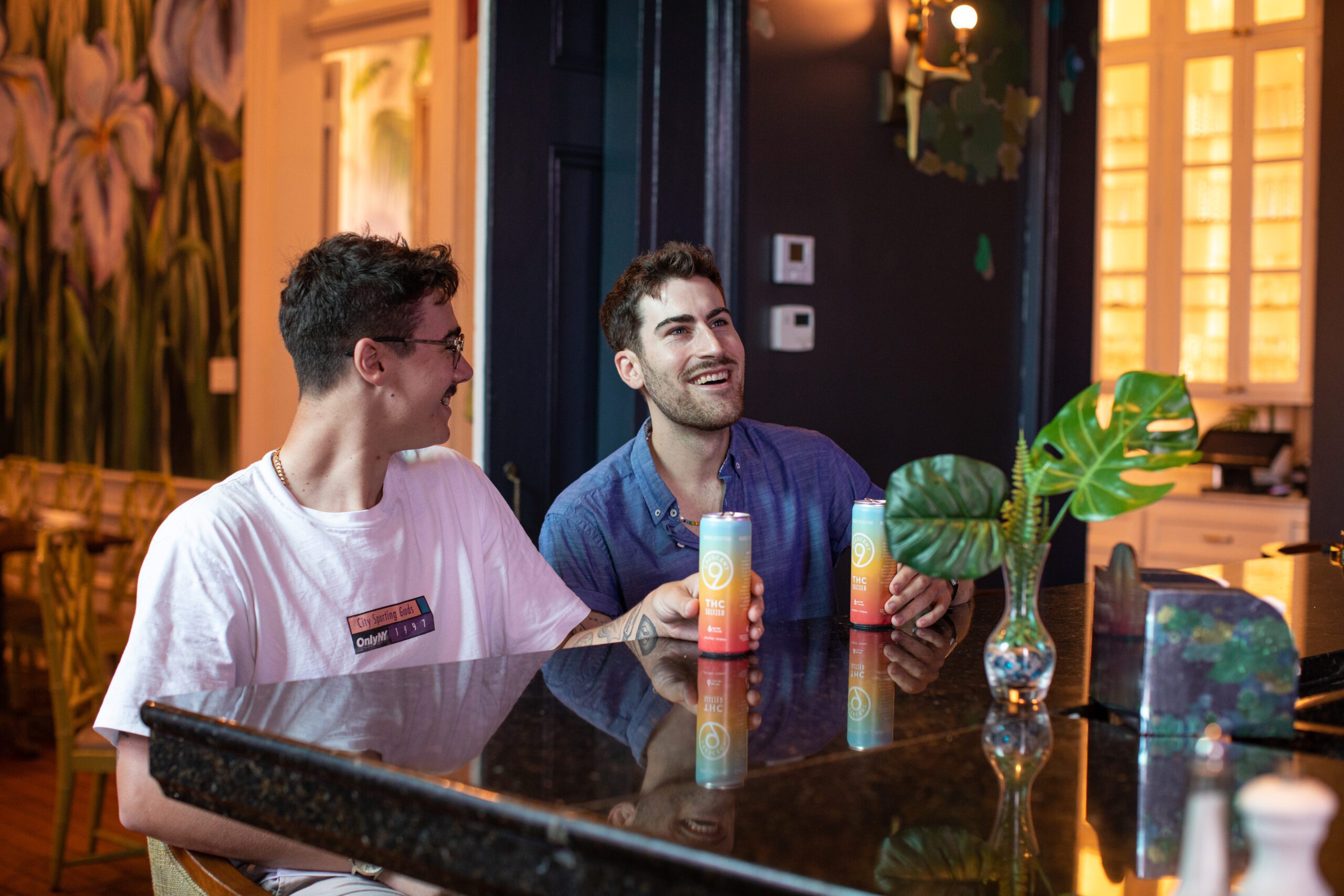 Two men at a bar with THC drinks