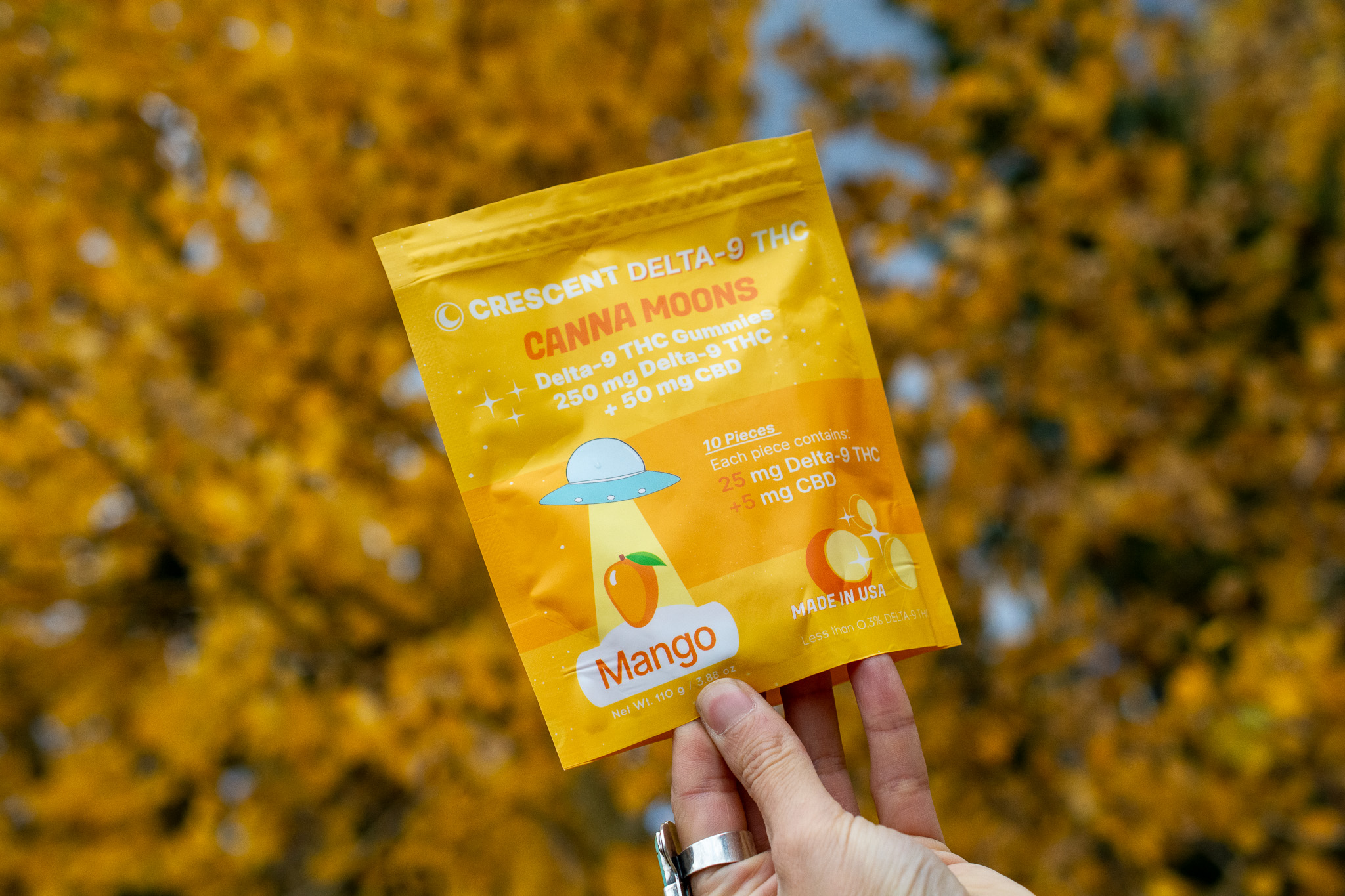Cannabis gummies in front of autumn trees.