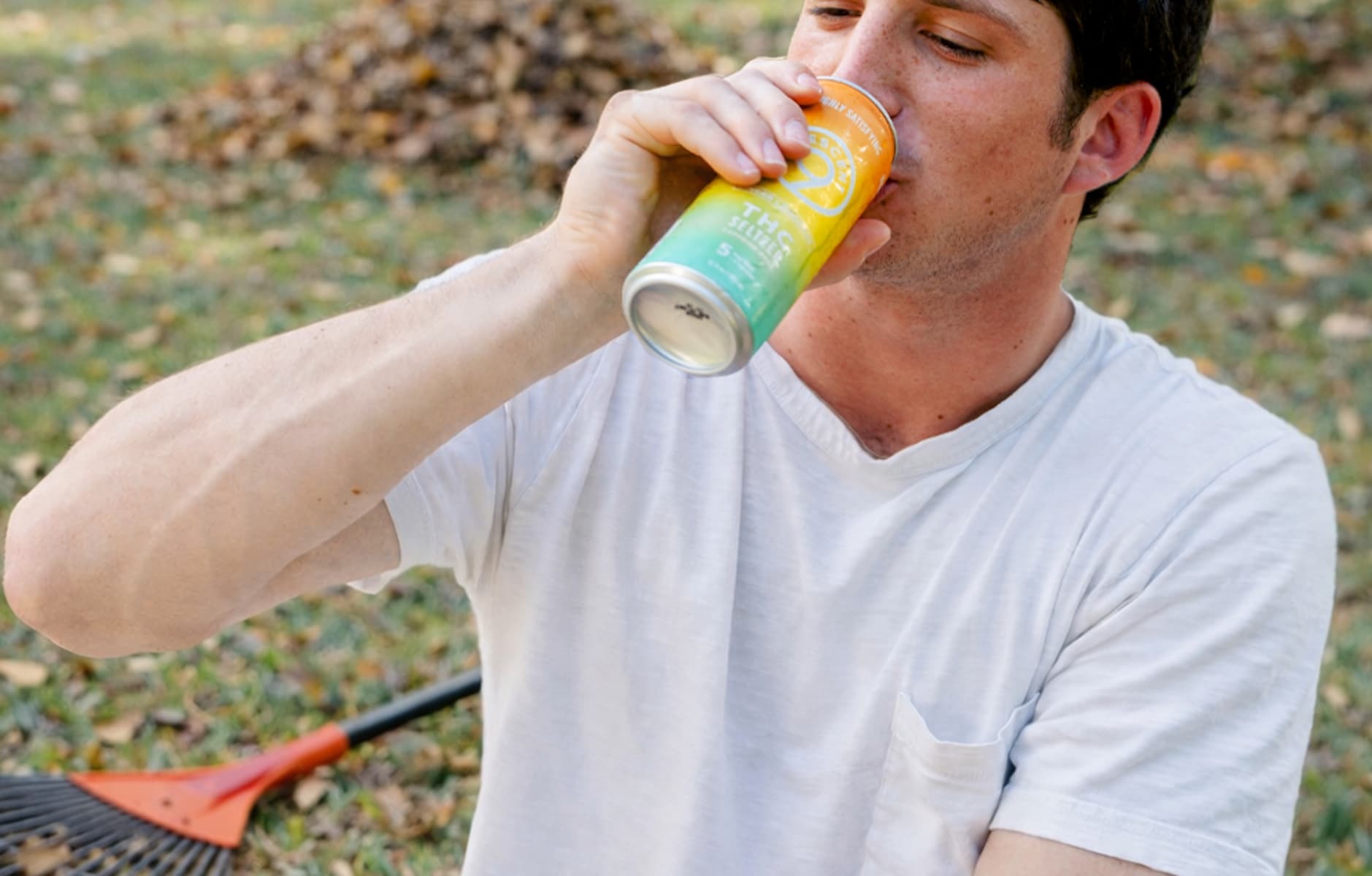 A man drinking THC drinks while doing chores