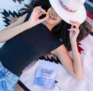 A woman enjoying a THC edible sleep gummy